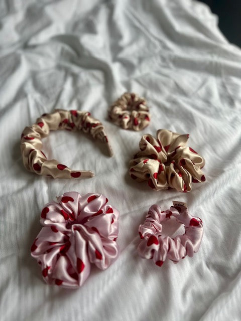 Eleganter rosafarbener Satin-Scrunchie, ideal für romantische Frisuren und Alltagslooks