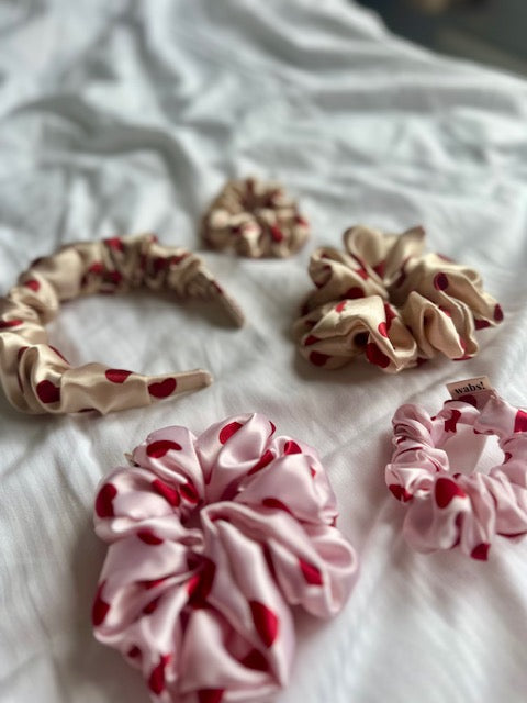 Eleganter rosafarbener Satin-Scrunchie, ideal für romantische Frisuren und Alltagslooks