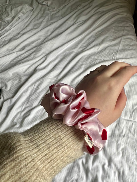 Eleganter rosafarbener Satin-Scrunchie, ideal für romantische Frisuren und Alltagslooks