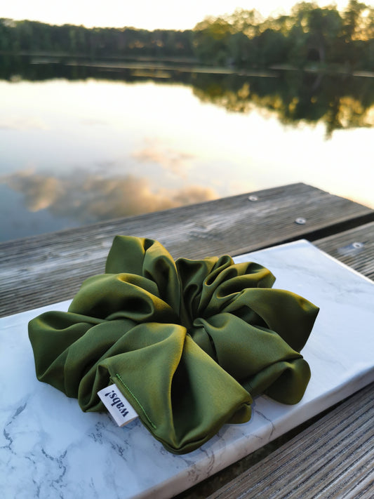 Olivegrüner Satin-Scrunchie, verleiht natürlichen Charme und hält das Haar sanft